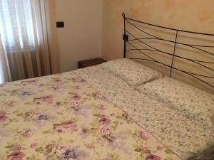 a bed with a floral comforter on it at Mia in Marina di Massa