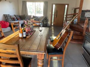 亚历山德拉Central Otago Farmlet的客厅里有一张木制餐桌，上面放着一把吉他。