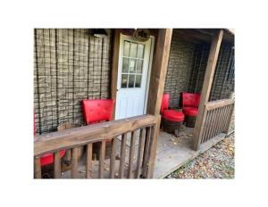un portico con sedie rosse e una porta bianca di Papa Bear Cabin 