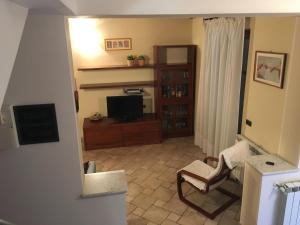 a living room with a chair and a television at Mia in Marina di Massa