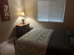 Un dormitorio con una cama y una lámpara en un tocador en North Delta Guest House Near Scott Rd, Transit, Airport 20 Min, Free Parking, en Delta 9 fotos más
