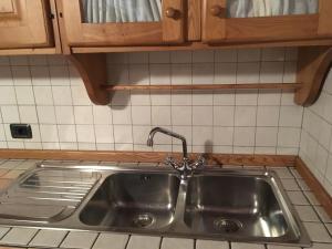 a stainless steel sink in a kitchen with wooden cabinets at Mia in Marina di Massa +37 photos