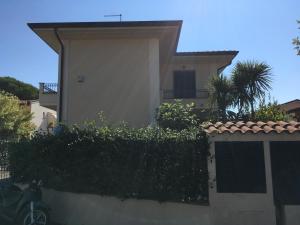 a house with a hedge in front of a building at Mia in Marina di Massa