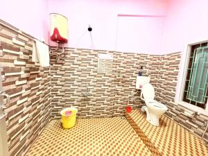 MajuliにあるSugandhalookのトイレとタイル張りの壁があるバスルーム