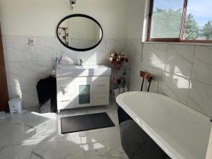 亚历山德拉Central Otago Farmlet的带浴缸、水槽和镜子的浴室