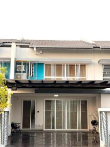 ein Haus im Regen mit einem Balkon in der Unterkunft Homestay D'Serenia Arina in Kampung Dengkil