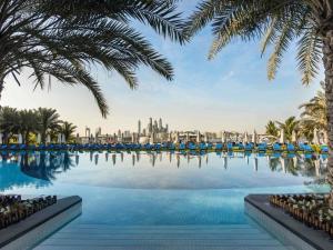 a swimming pool with a view of the city at Rixos The Palm Hotel & Suites - Ultra All Inclusive in Dubai