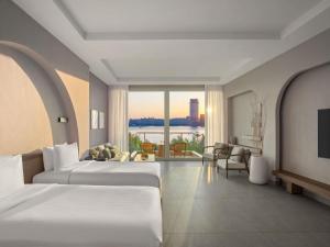 a hotel room with two beds and a large window at Rixos The Palm Hotel & Suites - Ultra All Inclusive in Dubai +257 photos