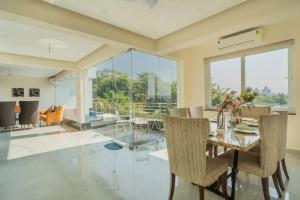 Un comedor con una mesa de cristal y sillas. en Luxury Apartments Candolim Luxfort, en Candolim