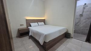 una camera da letto con un letto e una doccia in vetro di El Bakatir a Banyuwangi