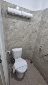 bagno con servizi igienici e asciugamani appesi a una parete di El Bakatir a Banyuwangi