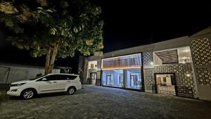 una macchina bianca parcheggiata fuori da un edificio di notte di El Bakatir a Banyuwangi