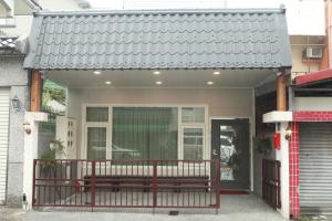 a house with a bench on the front porch at Sun Light Guesthouse in Hualien City