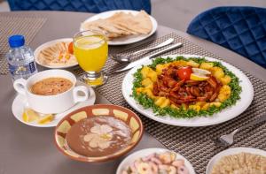 a table topped with plates of food and drinks at Sunday Jeddah Hotel in Jeddah