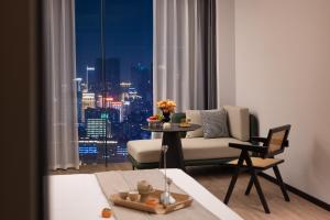 sala de estar con sofá y mesa frente a una ventana en Wuxuan Hotel Zoo Branch, en Chongqing