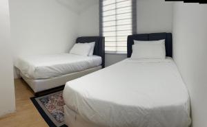 une chambre avec deux lits et une fenêtre dans l'établissement Inap Keranji Homestay With Pool, à Kota Bharu 5 autres photos