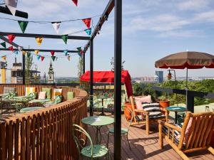 a patio with tables and chairs on a roof at Mama Shelter Belgrade in Belgrade
