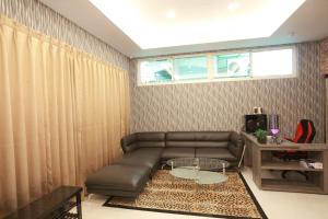 a living room with a leather couch and a table at Sun Light Guesthouse in Hualien City
