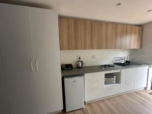 una cucina con elettrodomestici bianchi e armadietti in legno di Two Tides a Ballito Altre 5 foto