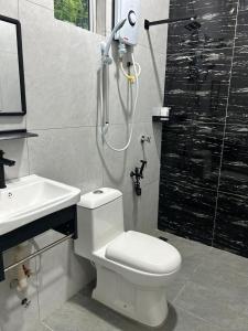 une salle de bains avec douche, toilettes et lavabo dans l'établissement Inap Keranji Homestay With Pool, à Kota Bharu