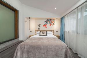 een slaapkamer met een groot bed en een groot raam bij Phoenix Geometry Light Accommodation in Fenghuang