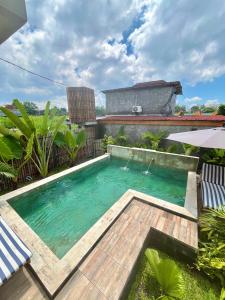 a small swimming pool with a wooden deck in a backyard at The Phalosaa Villa unit Family in Ngaglik