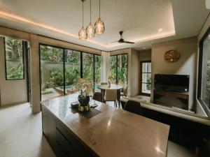 a living room with a large table and a dining room at Nusari Villa Ubud in Ubud