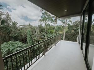 a balcony with a view of the forest at Nusari Villa Ubud in Ubud