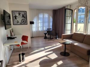 a living room with a couch and a table at Adagio Serris Val d'Europe in Serris +67 photos