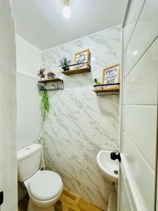 un baño con inodoro y lavabo en The ComfyNook Hostel, en Santa Maria