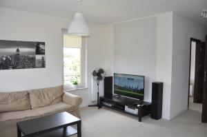 a living room with a couch and a flat screen tv at Apartamenty Tespis - Andersa in Katowice