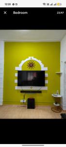 ein Wohnzimmer mit einem Flachbild-TV an einer grünen Wand in der Unterkunft Seaface Bldg1BHK Luxe service flat, Mumbai in Mumbai