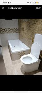 ein Badezimmer mit Toilette und Badewanne in der Unterkunft Seaface Bldg1BHK Luxe service flat, Mumbai in Mumbai