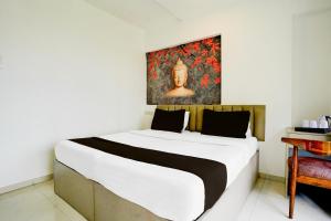 Un dormitorio con una cama grande con un cuadro en la pared. en Collection O Viviana Mall Thane West Formerly Athithi Stays, en Thane