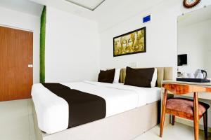 Un dormitorio con una cama, un escritorio y una mesa. en Collection O Viviana Mall Thane West Formerly Athithi Stays, en Thane