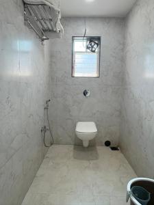 Un baño con inodoro y ventana. en Art of greens, en Mahabaleshwar 12 fotos más