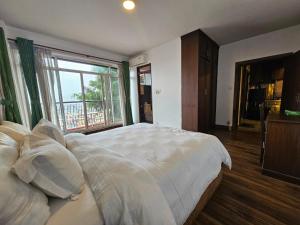 a bedroom with a large white bed with a window at Sagarmatha Apartment Hotel in Pātan