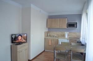 a kitchen and dining room with a table and a tv at Apartament Ustrzyki in Ustrzyki Dolne