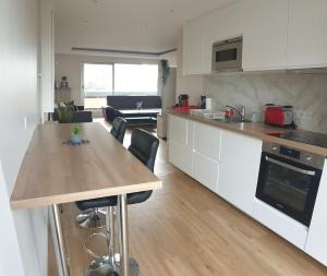 楠泰尔Appartment proche arena et la defense的配有白色橱柜和木桌的厨房
