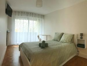 楠泰尔Appartment proche arena et la defense的卧室里有一张床，床上有一只泰迪熊