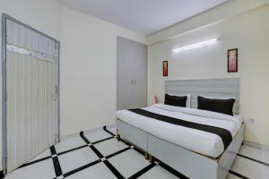 a bedroom with a large white bed in a room at Super Hotel O DLF Phase 1 Metro Station Gurugram in Gurgaon