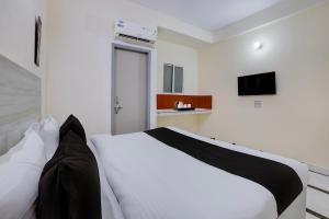 a bedroom with a white and black bed and a television at Super Hotel O DLF Phase 1 Metro Station Gurugram in Gurgaon +31 photos