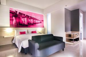 una camera da letto con un letto, una sedia e un quadro di favehotel Sudirman Bojonegoro a Bojonegoro Altre 27 foto