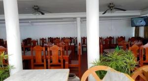 uma sala de jantar com uma mesa e cadeiras e uma ventoinha de tecto em Palm Grove Saud Holiday Complex Hotel em Burayoc