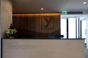a reception desk in an office with a sign on the wall at The Y House in Chiang Mai