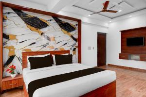 a bedroom with a large bed with a stone wall at Super Townhouse Whitefield Railway Station Formerly Kadugudi Whitefield in Bengaluru