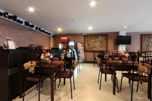 ein Speisesaal mit Tischen und Stühlen in einem Restaurant in der Unterkunft D' Leonor Hotel in Cabaguio