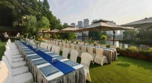 une rangée de tables avec des chaises blanches et une table bleue dans l'établissement Changzhou Fudu Qingfeng Garden Hotel, à Changzhou