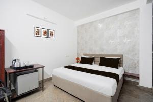 une chambre avec un grand lit et une table dans l'établissement Hotel O City Park Kota Formerly Oxyluxe, à Kota