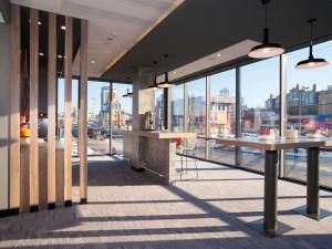 un restaurante con grandes ventanas y vistas a la ciudad en ibis Kyiv Railway Station, en Kiev